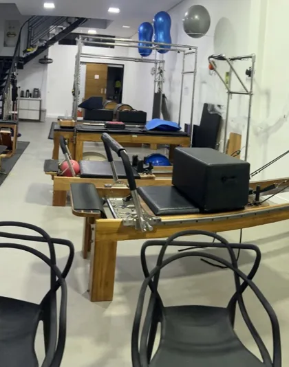 Salão do estúdio com aparelhos reformer e cadillac de Pilates